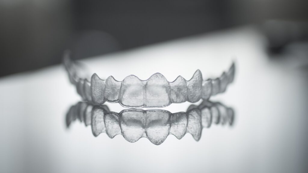 Allineatore trasparente Invisalign su sfondo neutro